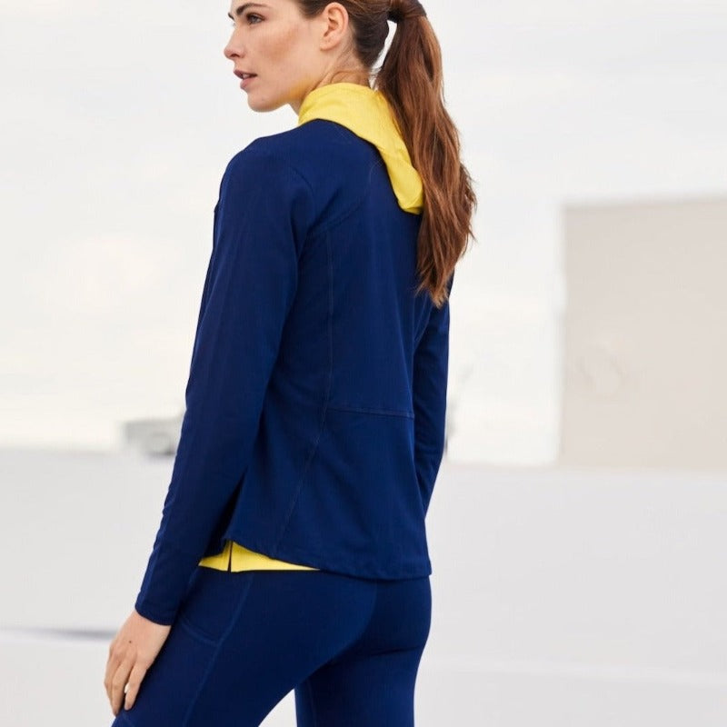 Image shows a woman wearing the Powerstretch Jacket in a side view. There's an early-morning fog in the background, creating a soft light. This comfortable, versatile Stretch Jersey Layering Jacket  is made using premium recycled materials and trims.UPF 50+. Classic Fit.