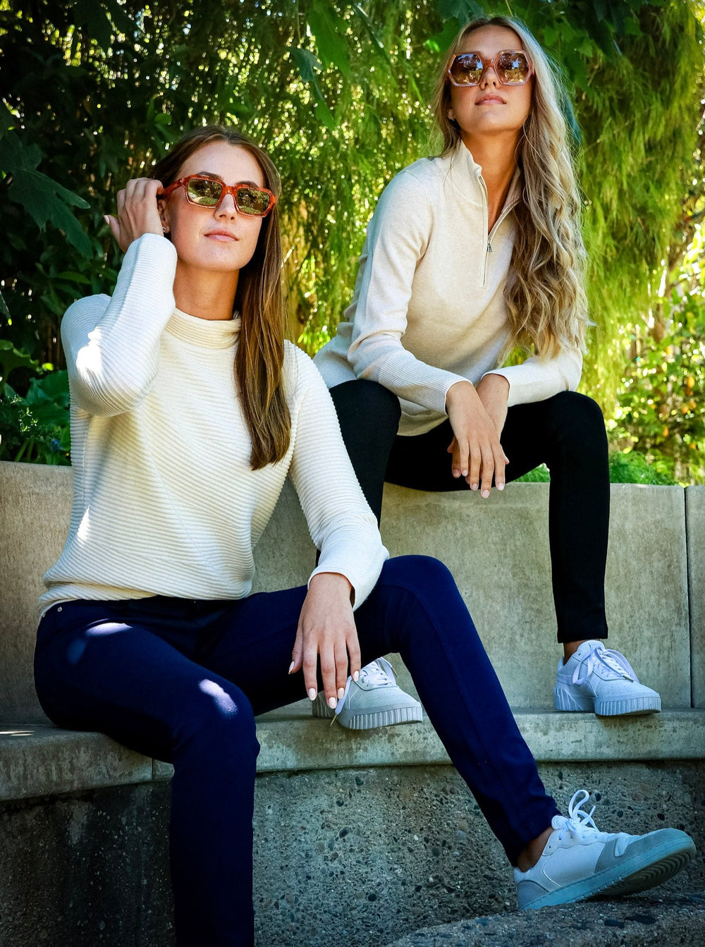 Free Shipping and Returns.  The image shows Two women casually seated on a stone park-bench. They are dressed sportily in the Movetes 5-Pocket Stretch Jersey Knit Pants, paired with the Ellie Rib Funnel Neck Mock Neck Sweater (Left), and the Luna !/4 Zip Organic Cotton-Seacell Sweater (Right). Seacell and Cotton are exceptionally soft yarns, and a great choice for anyone with sensitive skin. 